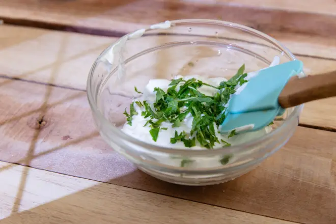 یک کاسه کوچک ماست با مقداری سبزیجات روی آن