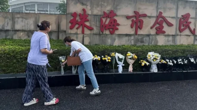 دو زن در حال گل گذاشتن پای دیوار