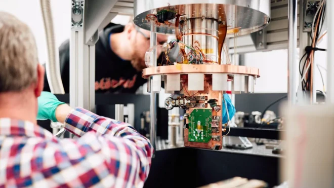  دو نفر در حال کار روی دستگاه تراشه‌ساز 