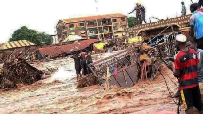 aworan ẹkun omi to n wọ ọpọ mọto lọ, to si bo ọpọ ile mọlẹ, awọn eeyan kan duro sori orule ile wọn