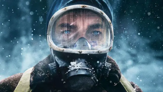 Zdjęcie pokazuje argentyńskiego aktora Ricardo Darína w roli Juana Salvo, protagonisty w serialu Netflixa "The Eternaut". Patrząc w kamerę, aktor znajduje się w śnieżnych warunkach, ubrany w zimowe odzienie i maskę gazową.