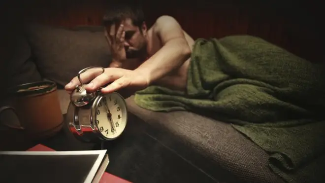 Man turns off alarm clock