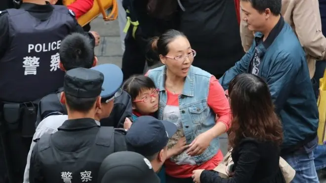 A mother hugs her daughter as they are leaving Mingtong Elementary School after a stampede killed six students and injured 22 in Kunming in Yunnan province, China, 26 September 2014