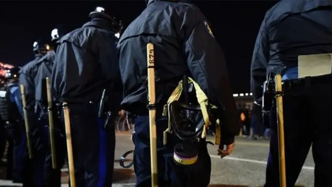 Police in riot gear line up against protesters in Ferguson, Missouri, on November 25, 2014