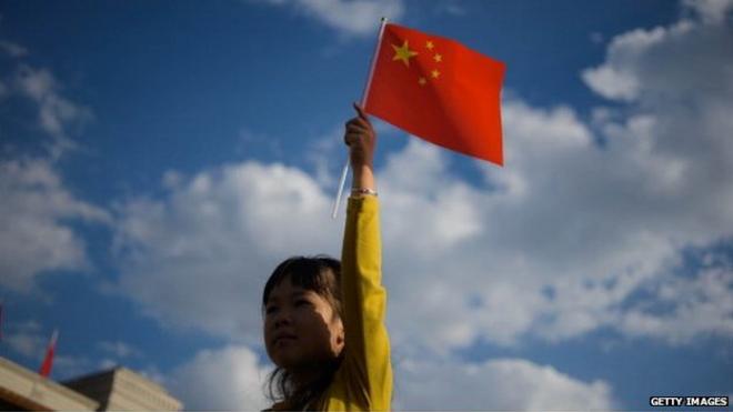 A girl waves a Chinese flag on Tiananmen Square in Beijing on 1 October, 2014