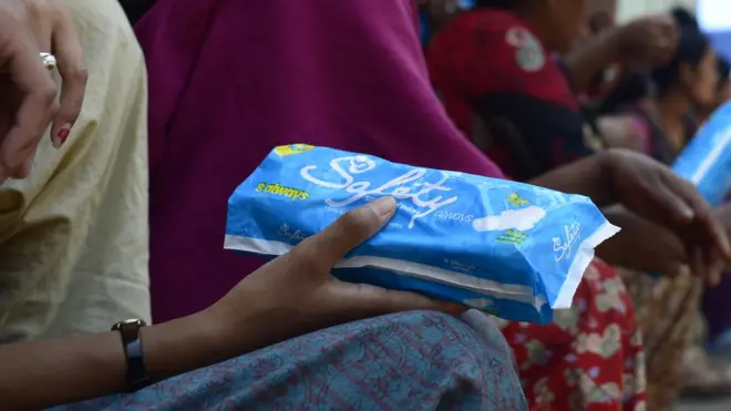 Woman holding a packet of sanitary towels