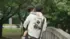 一名身穿連帽衫的男子抱著嬰兒走過公園裡的一座橋