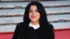 Marjane Satrapi siyah ceketle kameraya gülümserken