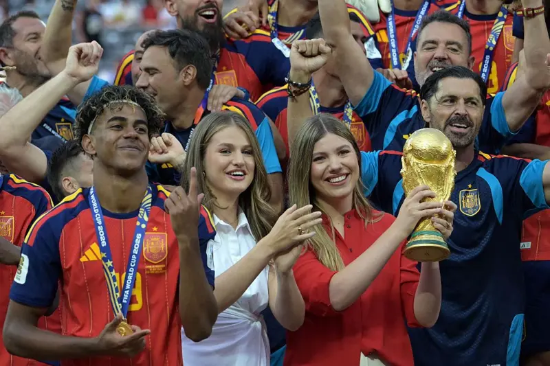 الأميرة صوفيا ترفع كأس العالم وسط احتفالات المنتخب الإسباني بالتتويج بلقب مونديال 2026، وإلى جانبها الأميرة ليونور والمهاجم لامين يامال، عقب الفوز على الأرجنتين في المباراة النهائية على ملعب نيويورك/نيوجيرسي في إيست راذرفورد بالولايات المتحدة، في 19 يوليو/تموز 2026.