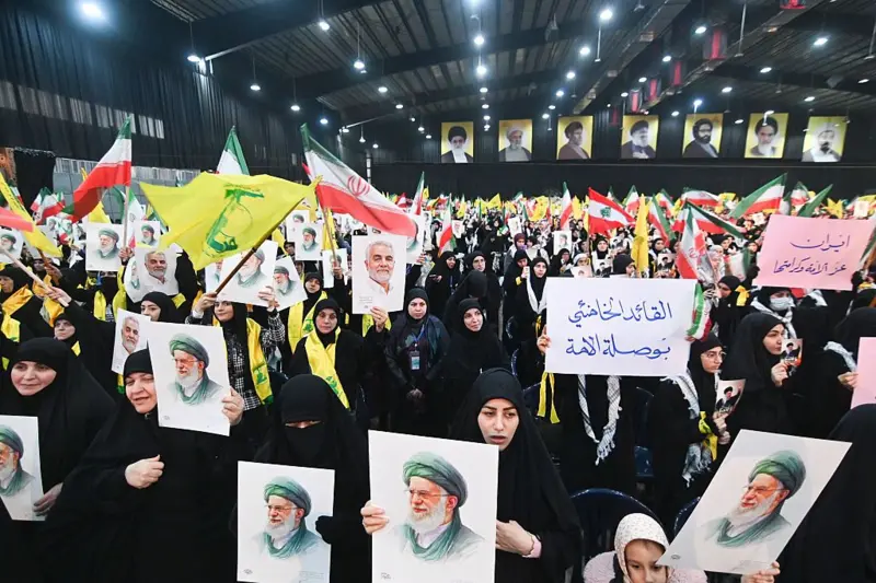 Hezbollah supporters in Lebanon holding photos of Iranian Ayatollah Ali Khamenei.