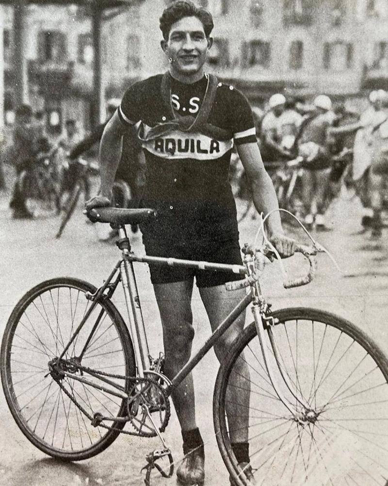 Photo noir et blanc d'un cycliste debout tenant son vélo devant lui