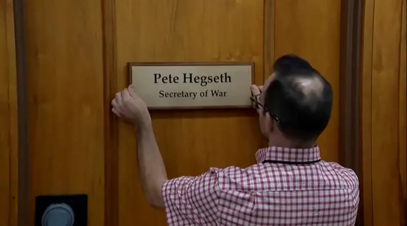 Image of a sign being changed to reflect the new Secretary of War title.