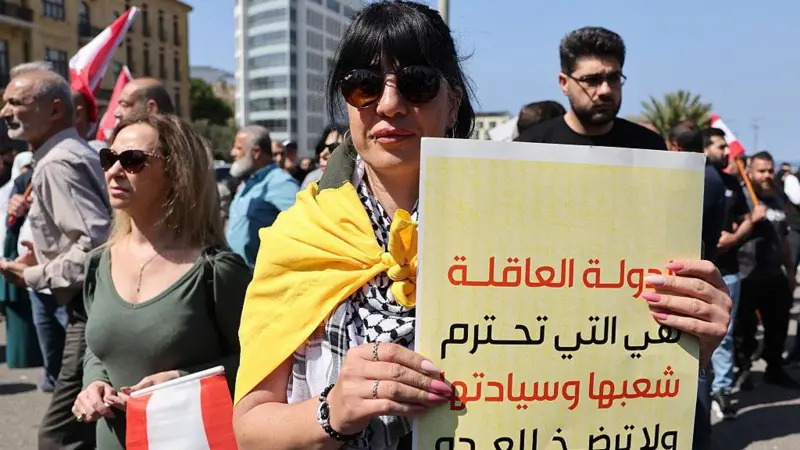 سيدة لبنانية ترفع لافتة كتب عليها: "الدولة الحكيمة تحترم شعبها وسيادتها ولا تخضع للعدو"، خلال احتجاج نظمه سكان ومخاتير وأهالي القرى الحدودية المدمرة في جنوب لبنان، في ساحة الشهداء وسط بيروت في 30 أبريل/نيسان 2026