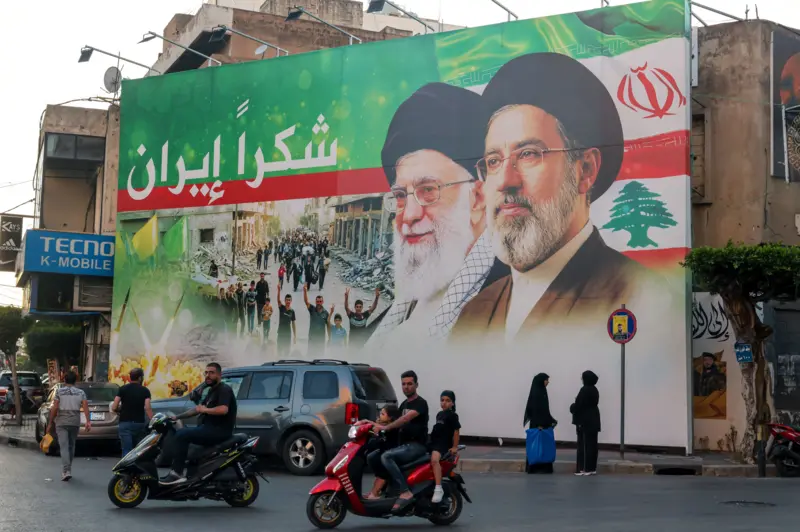 Mural depicting Ali Khamenei and his son Mojtaba on the façade of a building on a street in Iran.