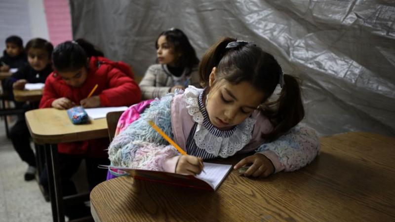 أطفال فلسطينيون يحضرون درساً داخل صف في مدرسة متضررة خلال وقفٍ لإطلاق النار بين إسرائيل وحماس في مدينة غزة، في 26 فبراير/شباط 2025