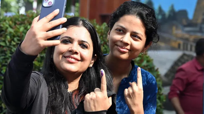 बिहार विधानसभा चुनाव 2025 के दौरान पटना वीमेंस कॉलेज स्थित एक मतदान केंद्र पर वोट डालने के बाद सेल्फी लेतीं वोटर्स