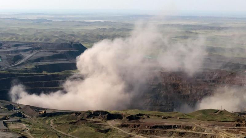 深色的塵雲從深坑中升起