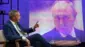 Найджел Фарадж перед экраном с изображением Владимира Путина во время интервью Би-би-си 21 июня