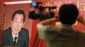 表紙に中国の元首相、朱鎔基氏が写った本のポスター。手前には男性とテレビカメラがぼやけて写っている。