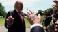 ホワイトハウスの屋外で記者団に囲まれたトランプ氏が、人差し指を上げてカメラを制止している