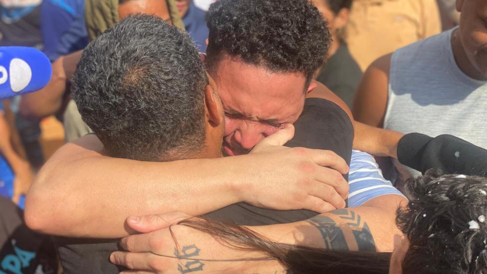 El joven venezolano Mervin Yamarte, repatriado a su nación tras estar preso en el CECOT de El Salvador, llora al abrazar a un familiar en el barrio Los Pescadores, en Maracaibo.