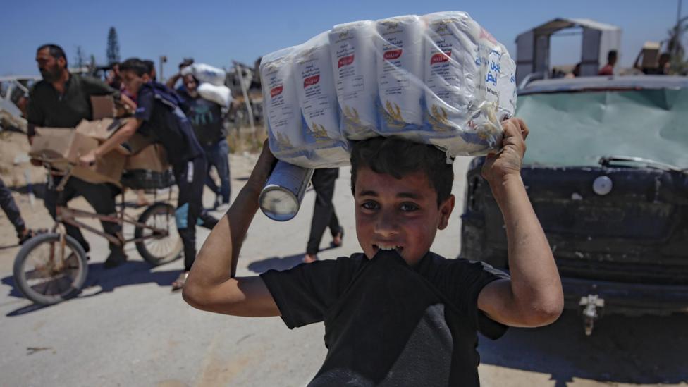 Menino carrega ajuda humanitária em Gaza