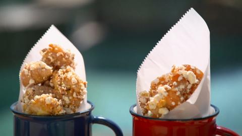 Tilly Ramsay's popcorn shrimp and chicken sit in blue and red mugs wrapped in white paper.