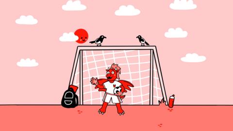 An animated red dragon in front of a football goal, holding a football and wearing a football kit.