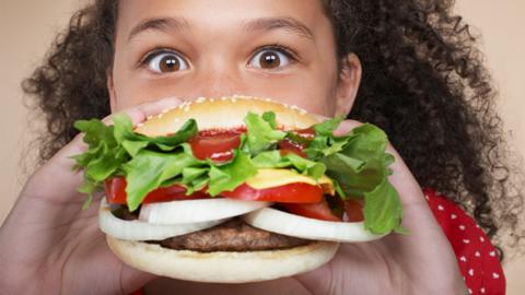 Child eating a burger.