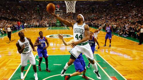 A Boston Celtics player attempts a slam dunk in the NBA.