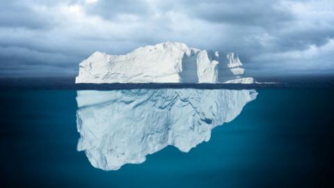 Iceberg Mostly Underwater Floating in Ocean.