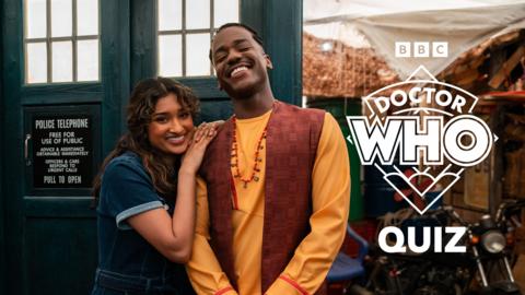 The Doctor and Belinda smile outside the TARDIS, the Doctor is wearing traditional Nigerian clothing.