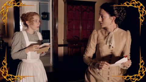 A young victorian maid is looking at a letter shocked. A woman looks at her. Hetty from Hetty Feather.