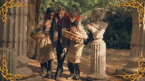 Two serving boys helping to carry an injured young man wearing a soldier's uniform in a garden, set in a gold frame.