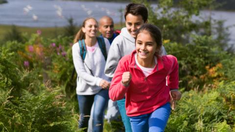 Family running through woodlands