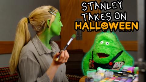 Stanley the monster in green fur for Halloween talking to a makeup artist