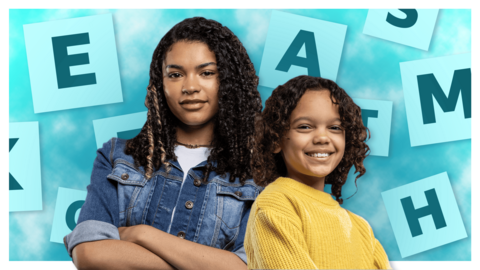 Two girls (a teenager and a child) are standing back to back whilst being surrounded by letters.