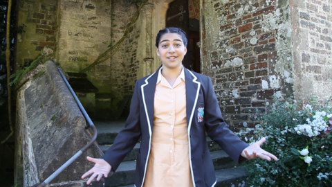 Zoey, who plays Alicia in Malory Towers, extends her arms in welcome to show us around The Abbey.