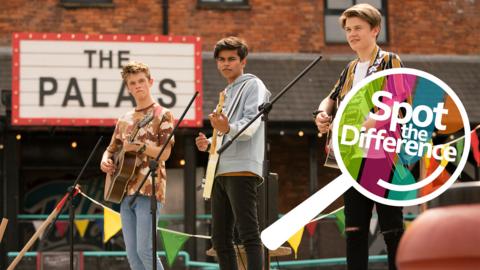 Three boys are performing on stage with their guitars.