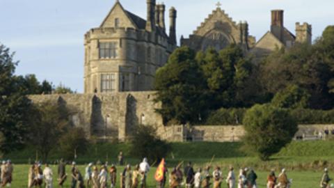Costumed archers and swordsman attacking a castle