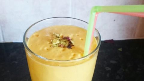 A glass of mango lassi with straws