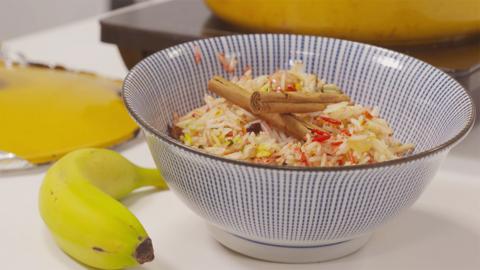 Somali Rice in a bowl, next to a banana.