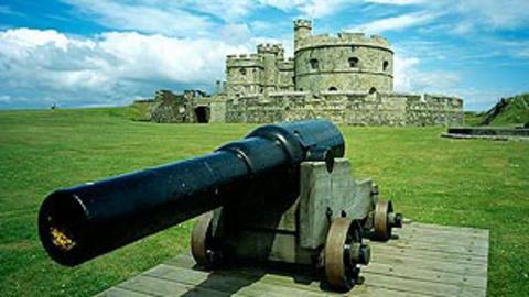 A Large cannon in the foreground with Pendennis Castle in the distance.