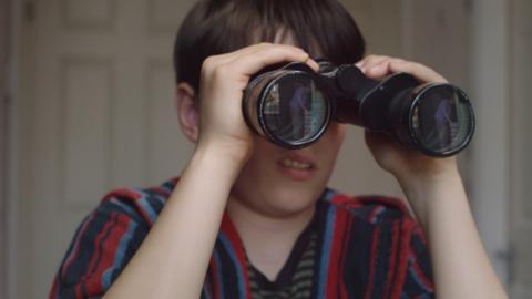 A boy looking through binoculars.