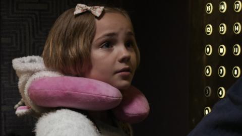 A girl looking worried in a lift.