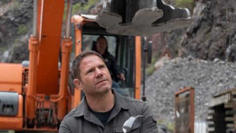 Steve sat below a huge metal dinosaur foot.