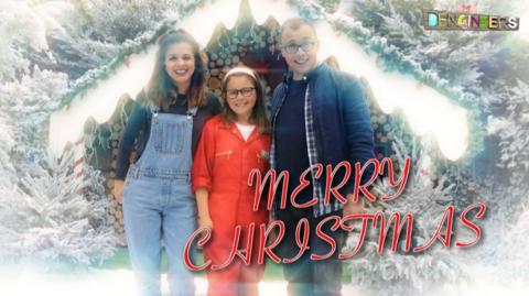 Lauren, Joe and Astrid stood in front of a Christmas den in the snow.