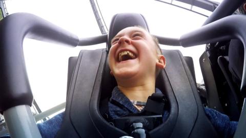 A boy on a rollercoaster.