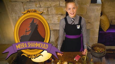 A girl standing behind a desk with potions ingredients, Ethel Hallow.