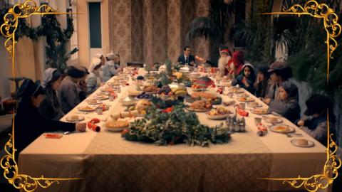 A table filled with Christmas dinner, surrounded by children.